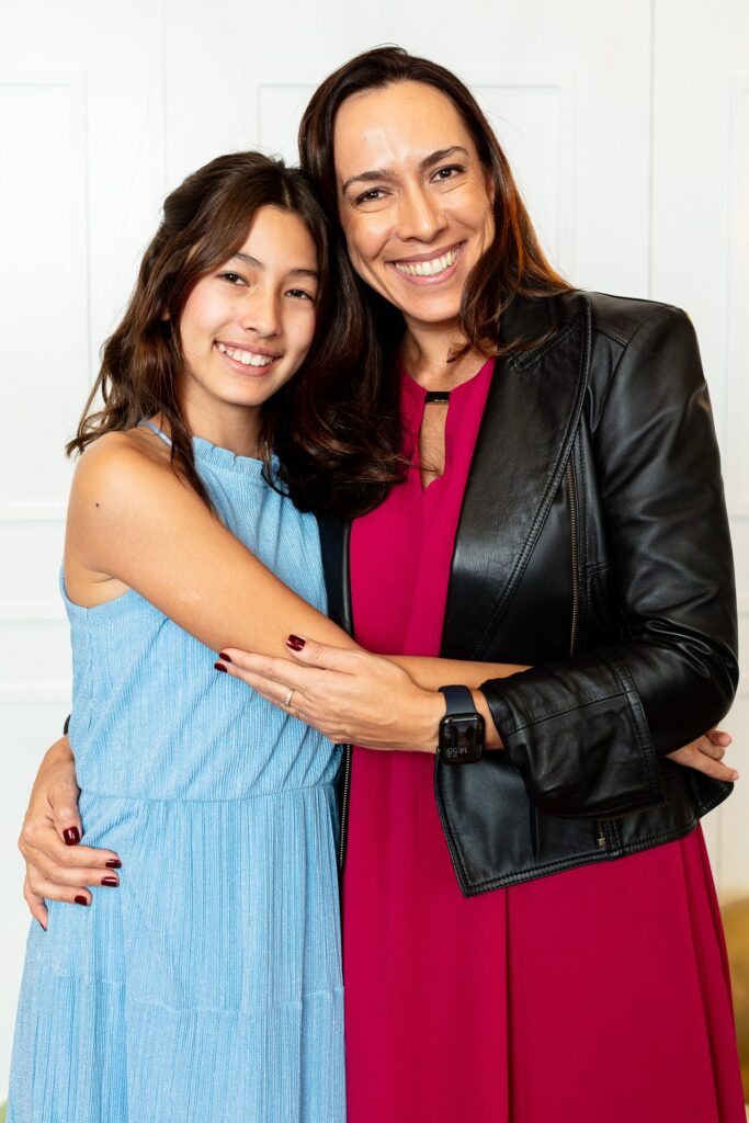 Aluna abraçada com a mãe durante a sessão de fotos de formatura na Escola Americana de Campinas.
